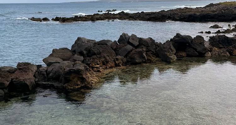 Bassin naturel de roche volcanique avec eau claire et littoral atlantique escarpé