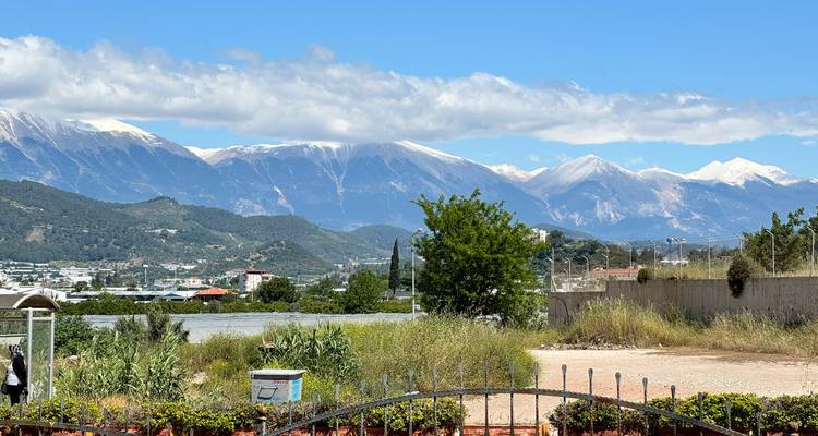 Chaîne de montagnes aux sommets enneigés au-delà de la zone suburbaine sous un ciel dégagé