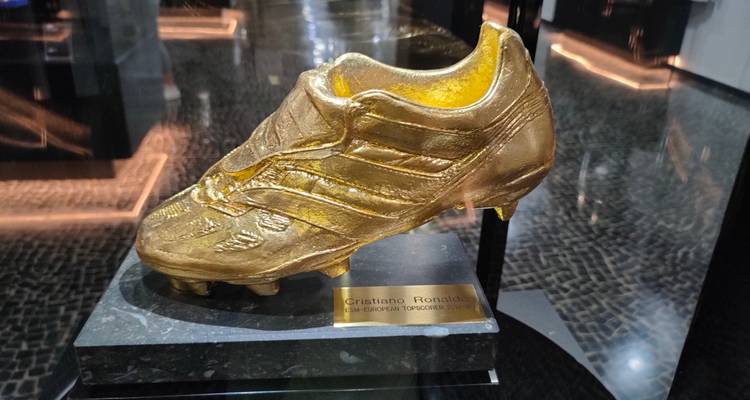 Een gouden voetbalschoen trofee ter ere van Cristiano Ronaldo tentoongesteld in een modern museumvitrine.