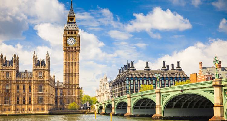 Le Big Ben emblématique et les Chambres du Parlement avec le pont de Westminster enjambant la Tamise sous un ciel bleu éclatant.