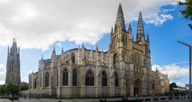 La Cathédrale gothique de Bordeaux s'élève majestueusement sous un mélange de ciel bleu et de nuages.