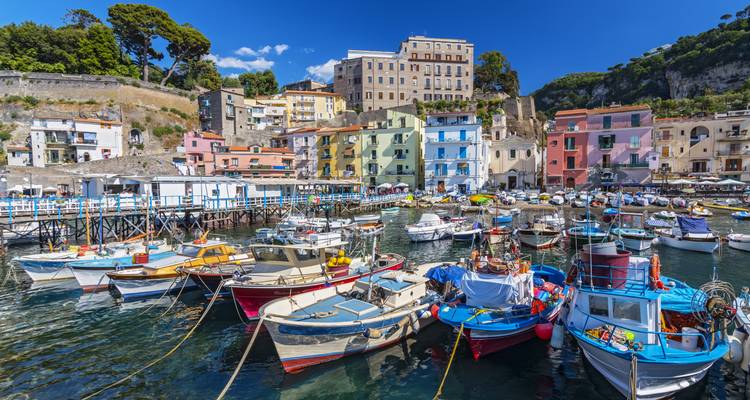 Les bateaux de pêche colorés se balançant doucement dans le port pittoresque de Sorrente, encadrés par les bâtiments aux couleurs pastel des collines environnantes