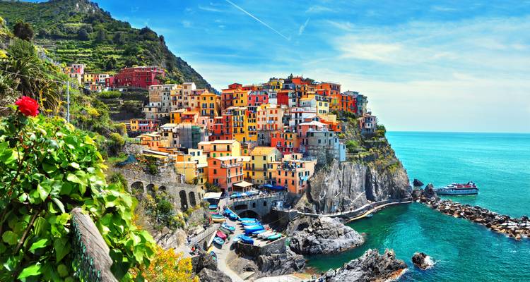 Vivido pueblo acantilado de Manarola con vistas al turqueso Mar de Liguria en un día soleado.