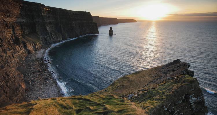 Coucher de soleil doré sur les Falaises de Moher et l'horizon de l'océan Atlantique.