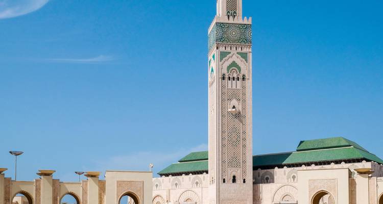El imponente minarete de la Mezquita Hassan II se alza contra un cielo azul despejado de Casablanca.