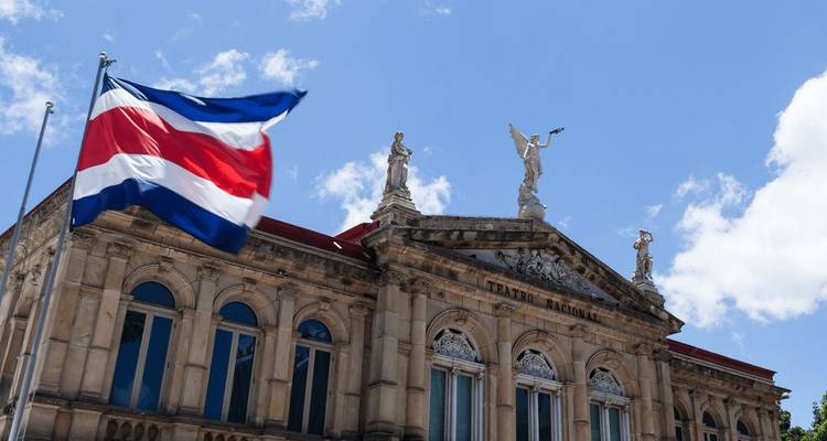 De vlag van Costa Rica wappert naast de sierlijke gevel van het Teatro Nacional in San José.