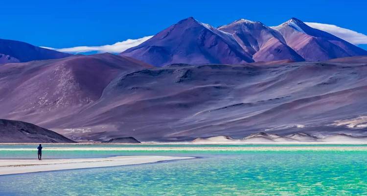 Las aguas turquesas de la Laguna Verde enmarcadas por las áridas montañas volcánicas en el Desierto de Atacama.