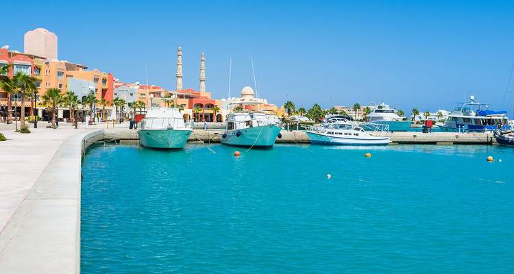 Türkisfarbenes Wasser und Vergnügungsboote im sonnigen Hafen der Strandpromenade des Resorts von Hurghada.