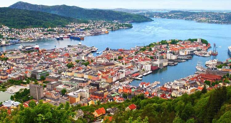Luchtfoto-panorama van een kuststad ingeklemd tussen fjorden en groene heuvels