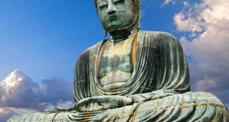 Close-up van het Great Buddha bronzen standbeeld tegen een blauwe lucht met wolken