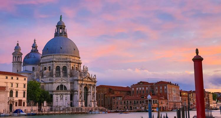Pastelkleurige zonsondergang over Venetië's Santa Maria della Salute en het Grote Kanaal
