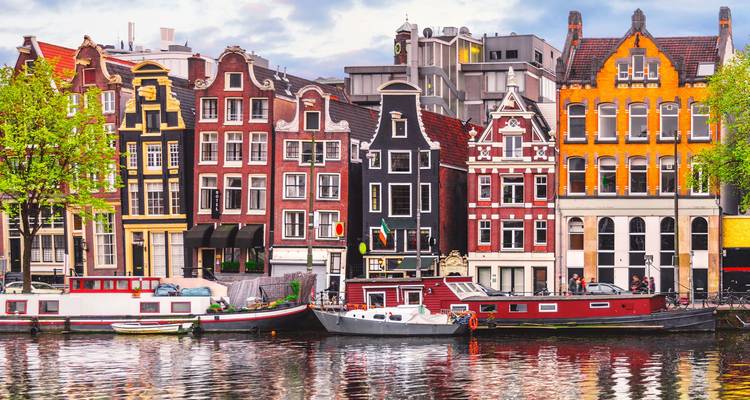 Les maisons colorées et les bateaux du canal se reflétant dans l'eau au centre d'Amsterdam.
