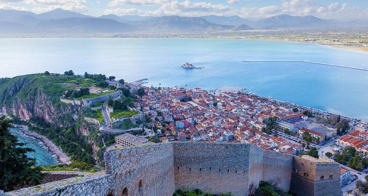 Uitgebreid uitzicht over Nafplions oude stad, vestingmuren en blauwe golfwaters.
