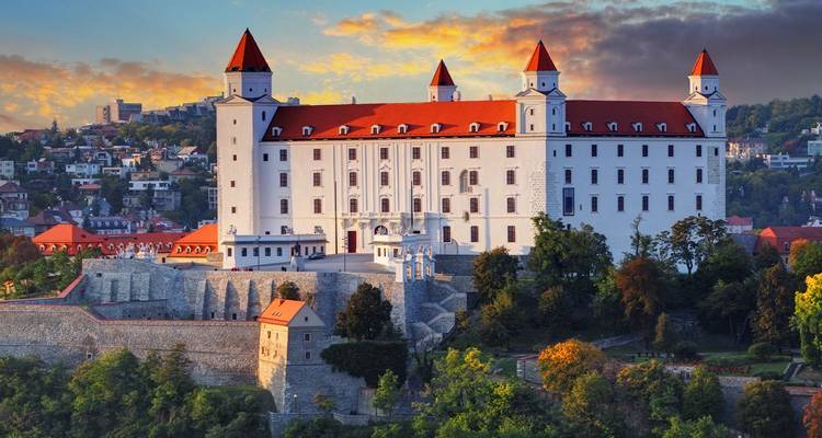 Bratislava Castle met rode daken die de skyline domineren bij een kleurrijke zonsopgang