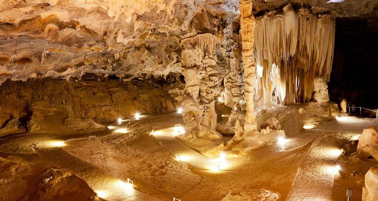 Estalactitas de piedra caliza iluminada y cámaras dentro de una amplia cueva de espectáculo.