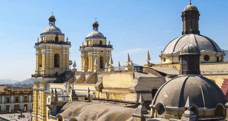 De twee gele klokkentorens en koepels van Lima's San Francisco Kerk steken uit boven de koloniale wijk.