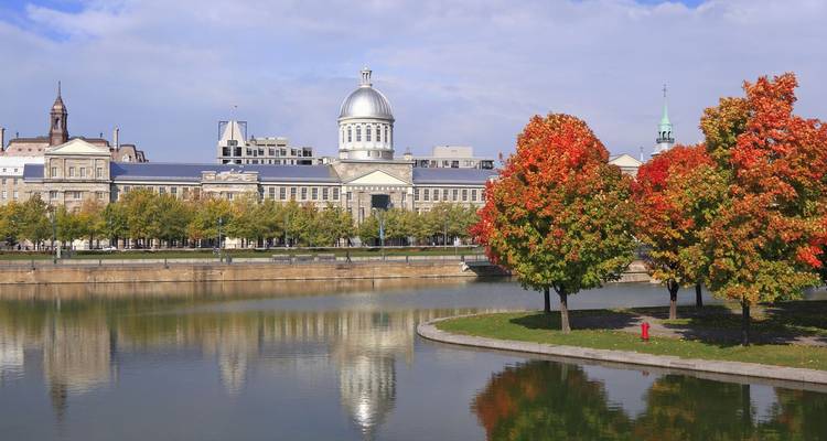 El domo plateado del Mercado Bonsecours se reflejaba en un tranquilo canal bordeado de árboles otoñales coloridos en Montreal.