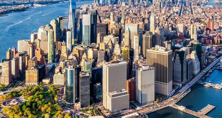 Sonnenbeschienenes Luftpanorama von Lower Manhattan mit Wolkenkratzern, Battery Park und dem Hudson River.
