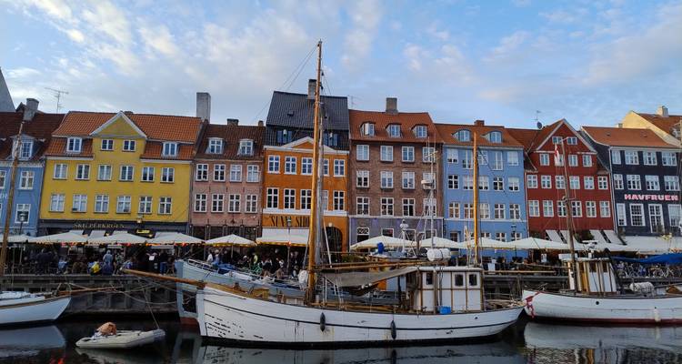 Les bateaux à voile en bois historiques amarrés le long des maisons de ville colorées de Nyhavn se reflètent dans les eaux calmes du canal