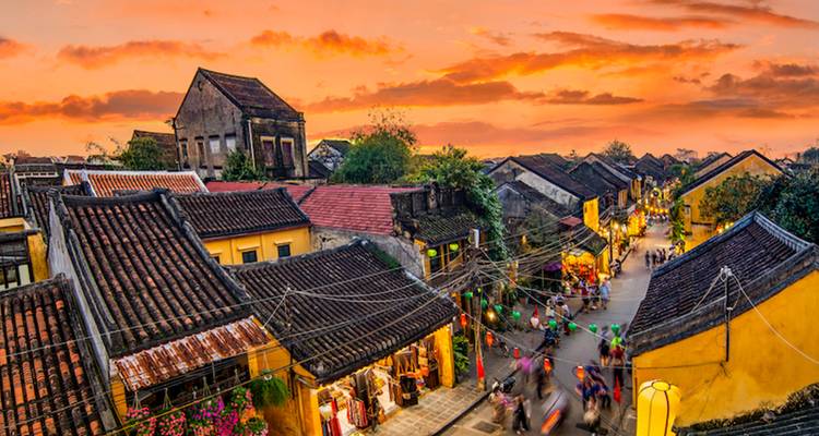 Vibrant sunset bathes Hoi An’s rooftops and lantern-lit streets in warm colors.