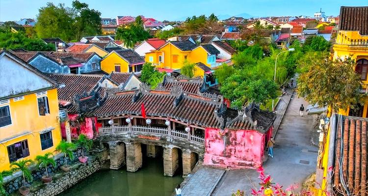 Japanese Covered Bridge spans a canal amid brightly painted houses in Hoi An.