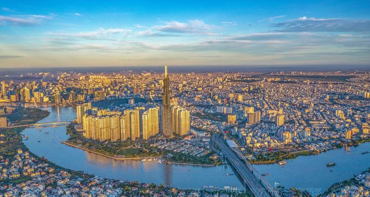 Helle Mittagsluftaufnahme von Ho-Chi-Minh-Stadt mit dem Landmark 81, das sich über die Biegung des Saigon-Flusses erhebt.