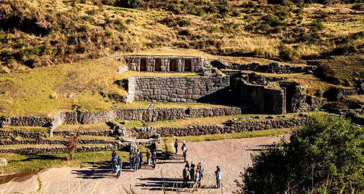 Kleine Gruppe erkundet Steinterrassen und Wasserkanäle der Inkaruinen in der Nähe von Cusco