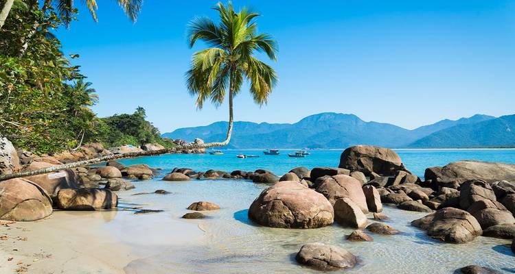 Anse tropicale idyllique sur l'Ilha Grande avec des palmiers, une eau turquoise et des rochers de granit.
