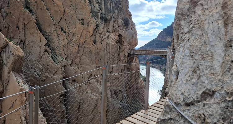 Schmaler hölzerner Holzsteg, der sich an eine steile Canyonwand am Caminito del Rey Wanderweg anschmiegt.