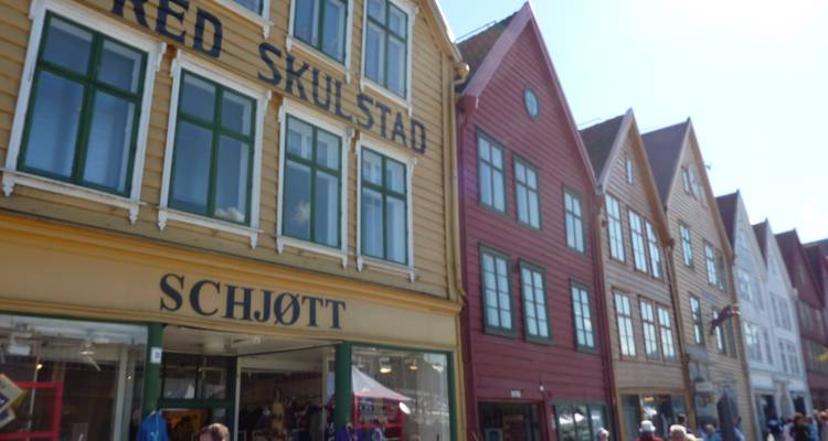 Vue de rue légèrement floue des façades colorées et des vitrines de Bryggen par une journée ensoleillée.