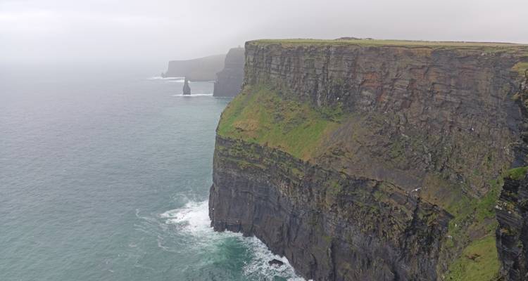 Acantilados oceánicos espectaculares que se despeñan en las olas turquesas del Atlántico a lo largo de la famosa costa de Irlanda.