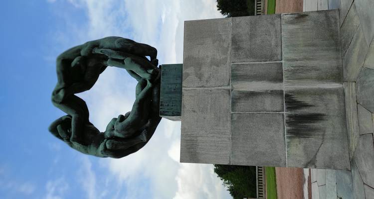 Sculpture en bronze de mains entrecroisées formant un cercle, montée sur un socle en pierre dans le parc Vigeland.