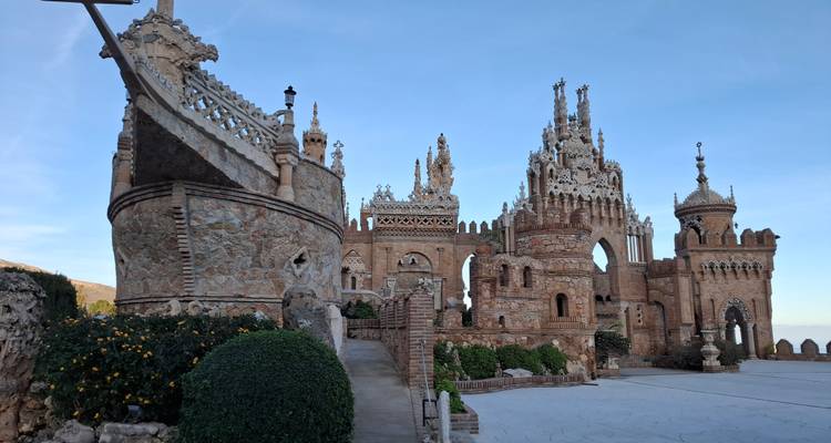Château de Colomares de style conte de fées avec des tourelles et une maçonnerie détaillée sous un ciel dégagé.