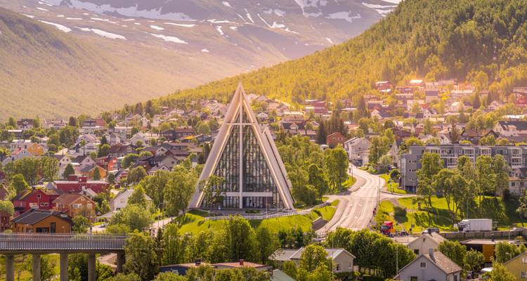 Lumière dorée du soir dans la vallée de Tromsdalen mettant en évidence la Cathédrale arctique entourée de verdure.
