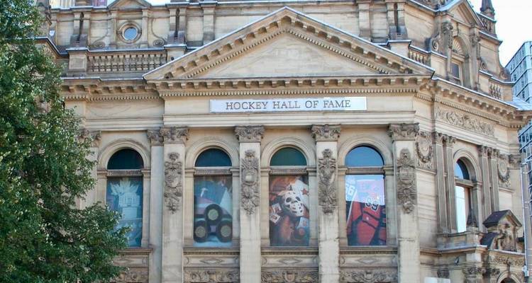 Façade du Temple de la Renommée du Hockey présentant des colonnes ornées et des vitraux à thème sportif.