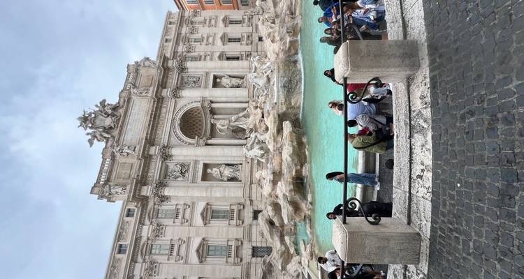 La Fontana di Trevi con su piscina turquesa y esculturas rodeadas de multitudes y arquitectura Barroca.