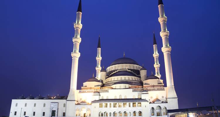 Nachtansicht der majestätischen, gegen einen tiefblauen Himmel beleuchteten Kocatepe-Moschee in Ankara.
