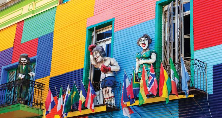 Lebendige Patchwork-Fassaden von La Boca mit verspielten lebensgroßen Statuen und Reihen von Flaggen aus aller Welt.