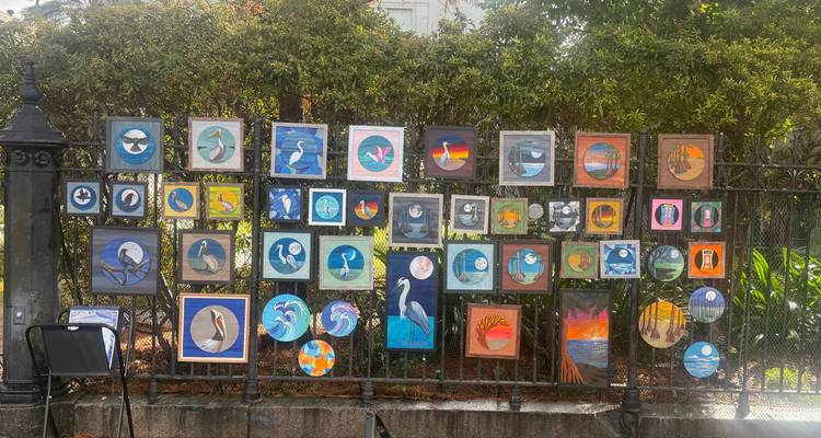 Exposition de clôture extérieure de petites peintures d'oiseaux colorées à vendre dans un marché de rue artistique.