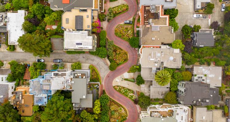 Vue aérienne de haut en bas de la sinueuse rue Lombard de San Francisco, bordée par des maisons colorées et des jardins luxuriants.