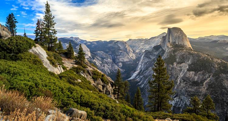 Vue panoramique du Half Dome et de la High Sierra depuis le Glacier Point aux couleurs de l'aube.