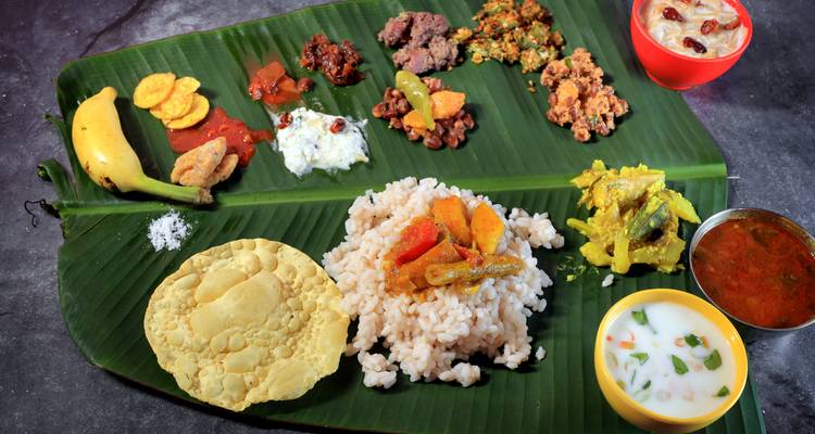 Festín tradicional de Kerala servido en hoja de plátano con arroz, curries y papadum.