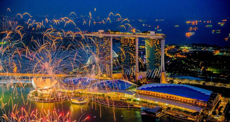 Brillante Feuerwerke erleuchten das Marina Bay Sands und die Hafenpromenade während einer nächtlichen Feier.