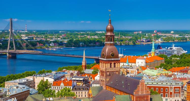 Luftaufnahme von Riga mit Domspitze, Fluss und Schrägseilbrücke an einem klaren Tag