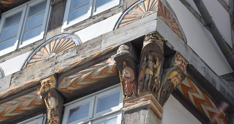 Detail van ingewikkelde houten spantwerk-snijwerk en geschilderde balken op een historisch vakwerk huis in Hameln.