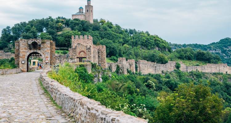 Mittelalterliche Steinmauern und Türme der Festung Tsarevets, die sich über grünen Hügeln in Veliko Tarnovo erheben.