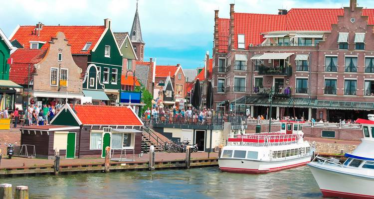 Des maisons en bois colorées, des restaurants et des bateaux le long du port animé de Volendam.