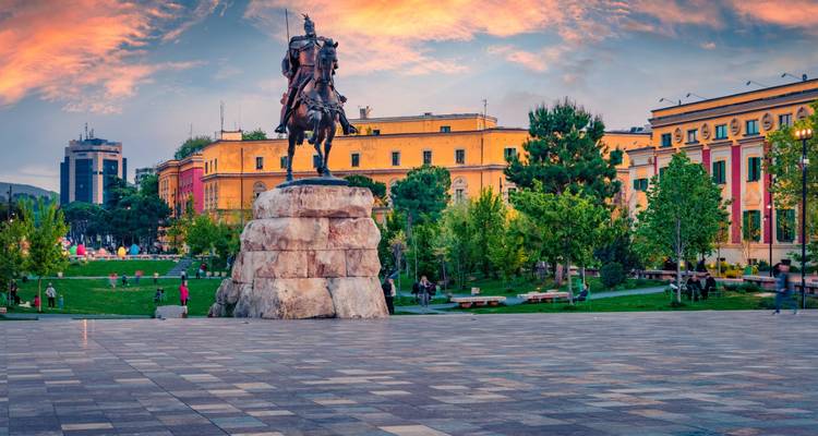 Skanderbeg statue dominating Tirana’s central plaza during a colourful sunset.