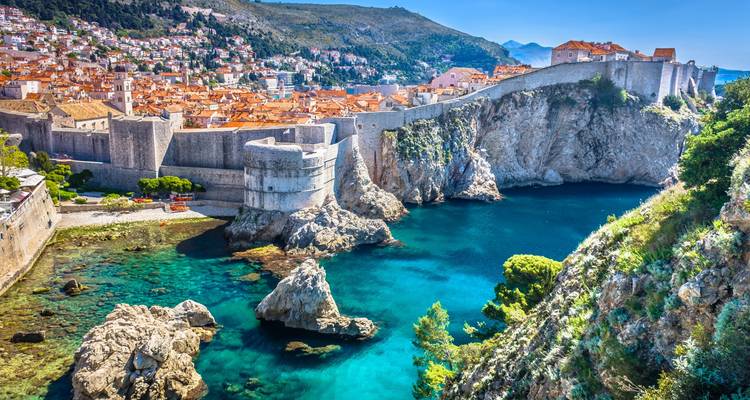 Die kristallklaren Gewässer der Adria umhüllen die befestigten Steinmauern und Klippen der Altstadt von Dubrovnik.
