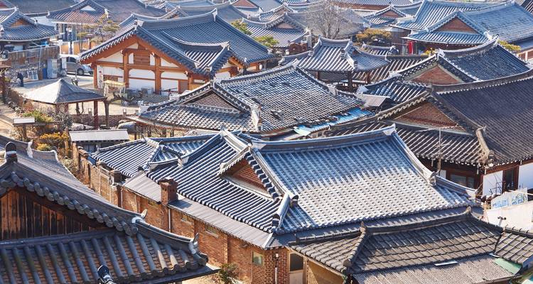Les toits carrelés d'un vaste village hanok traditionnel coréen vus de haut par une journée ensoleillée et claire.